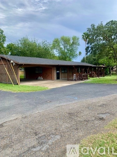 A large wooden building with a dark roof and a covered porch.