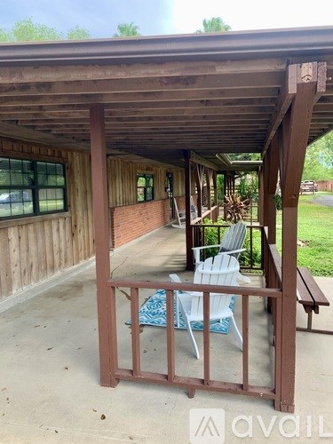 A wooden porch with a bench and chairs.