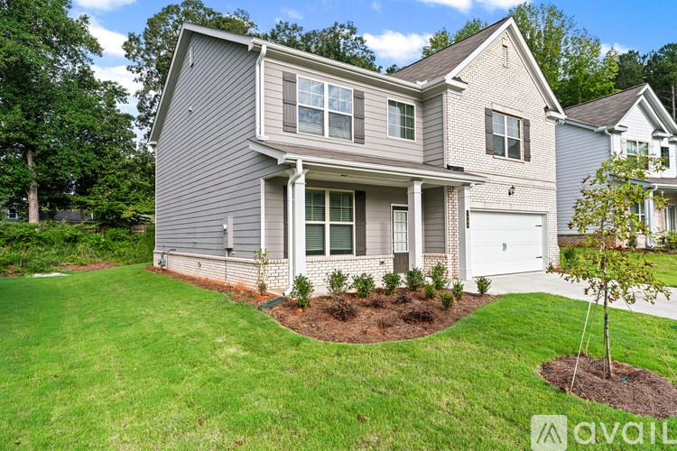 A house with a grey siding and a white garage door.