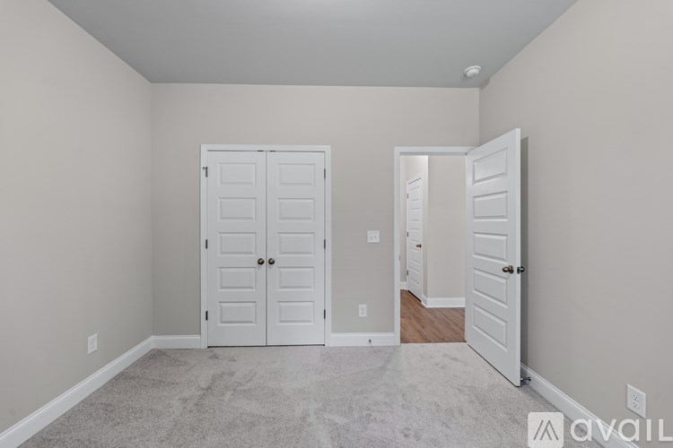 A room with two white doors and a carpeted floor.