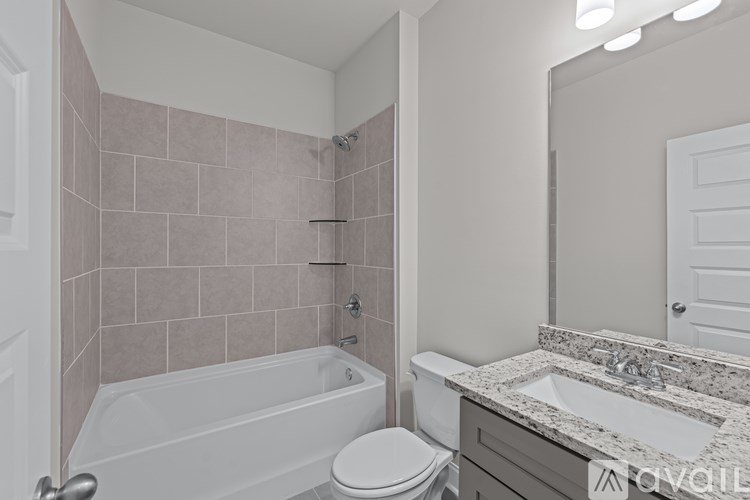 A bathroom with a tub, toilet, and sink.