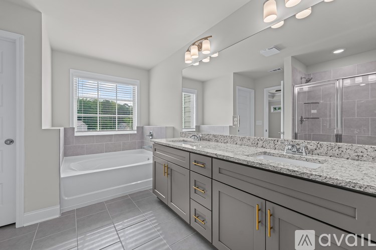 A bathroom with a tub, sink, and mirror.