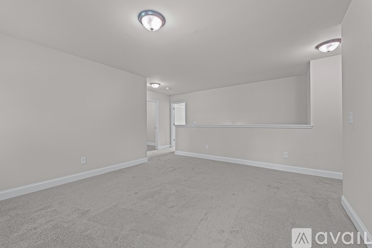 A spacious room with carpeted floor and white walls.