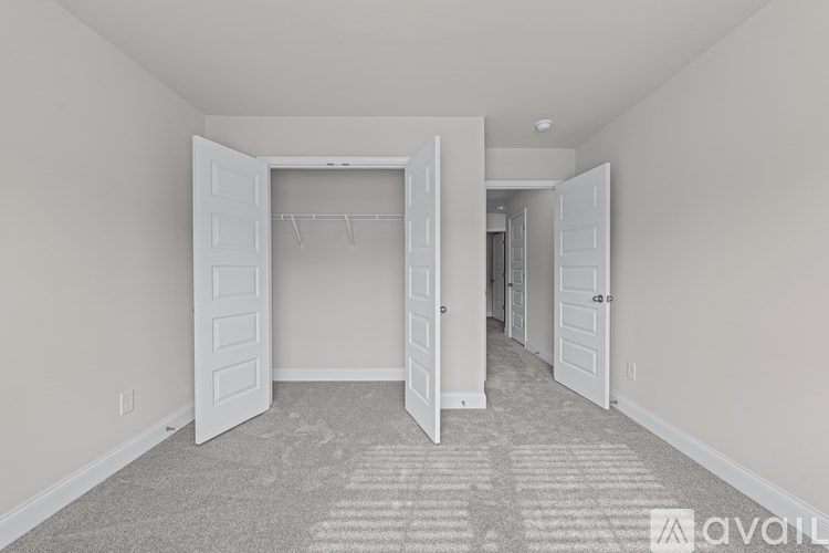 A room with a carpeted floor and a white door.