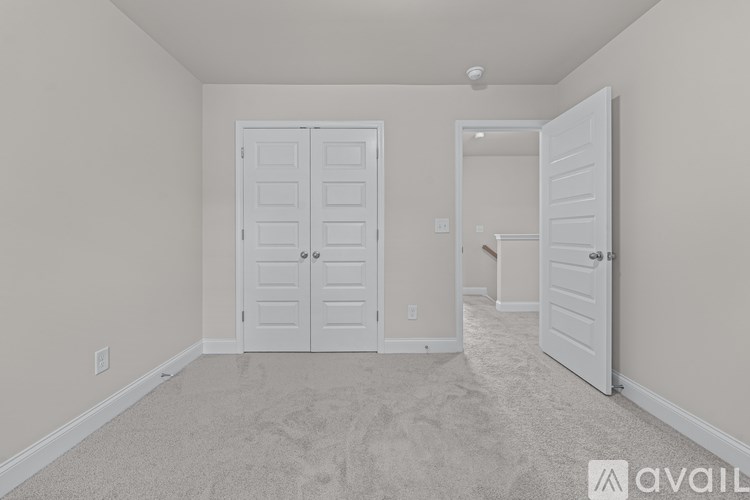 A room with two doors and a carpeted floor.