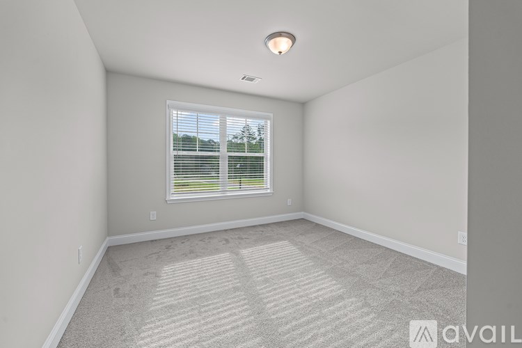A room with a window and carpeted floor.