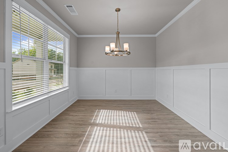 A room with a wooden floor and a chandelier hanging from the ceiling.