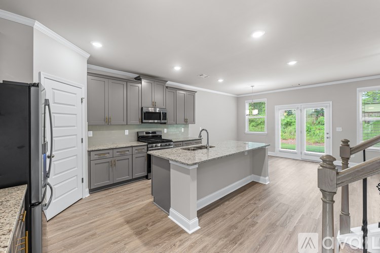 A modern kitchen with a refrigerator on the left and a countertop with a sink.