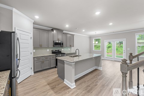 A modern kitchen with a refrigerator on the left and a countertop with a sink.