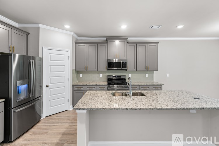 A kitchen with a granite countertop and stainless steel appliances.