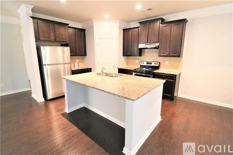 A kitchen with a granite countertop and dark brown cabinets.