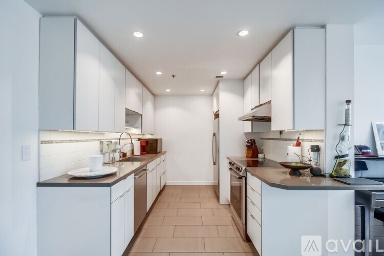 A modern kitchen with white cabinets and appliances.