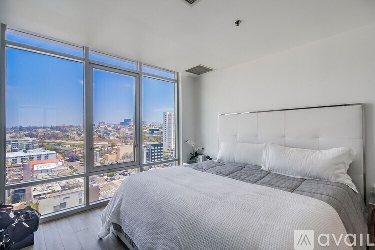 A bedroom with a large bed and a view of the city.