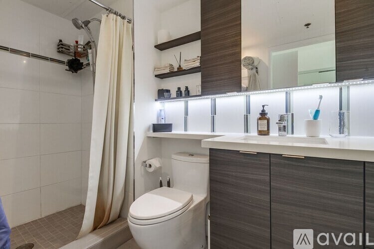A bathroom with a toilet, sink, and shower area.