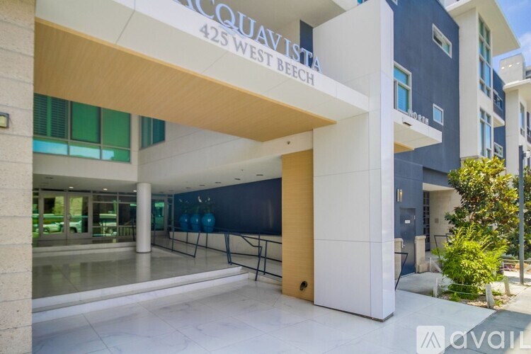 The image shows a modern building with a glass entrance and a sign that reads "425 WEST BEACH".
