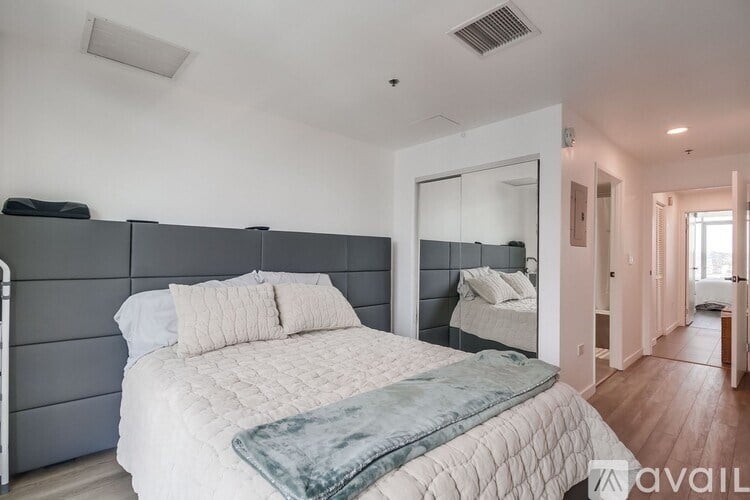 A bedroom with a large bed and a mirror on the wall.