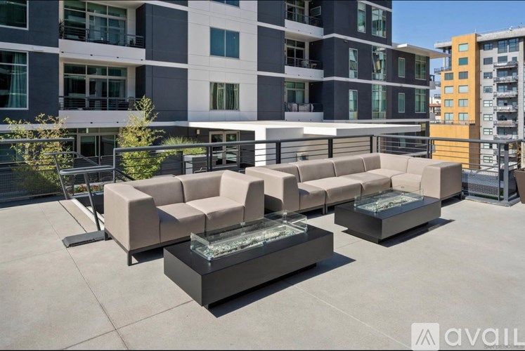 A patio with a couch and a table in front of a building.
