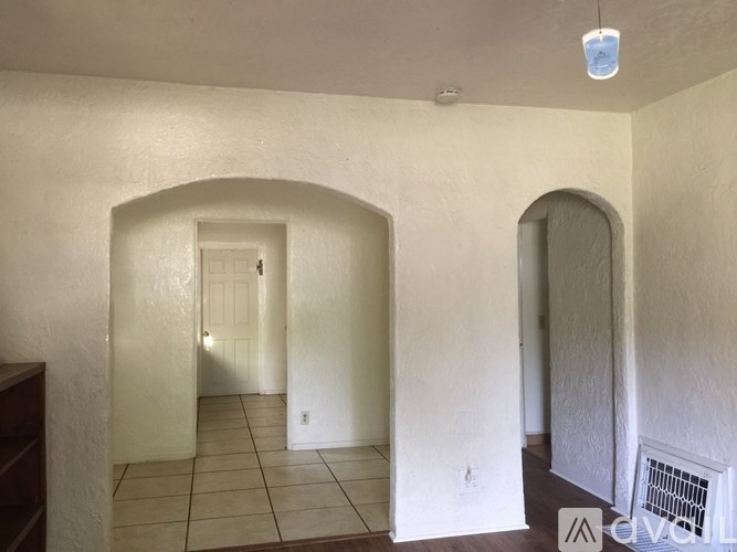 A hallway with a white door and a window.