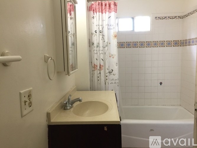 A bathroom with a sink, mirror, and bathtub.