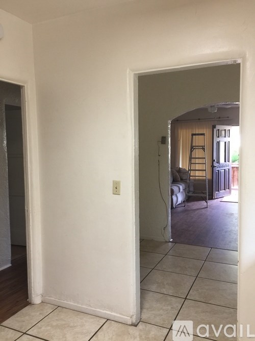 A room with a white wall and a doorway leading to another room.