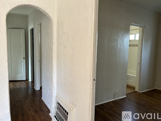 A hallway with a white door and a window.