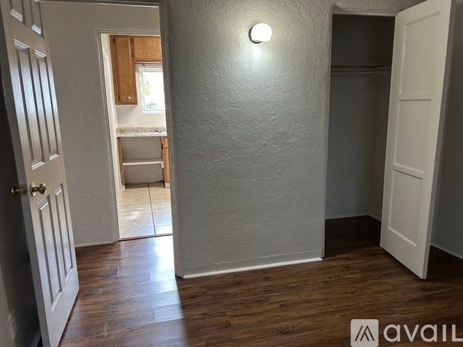 A hallway with a light on the wall and a door on the right.