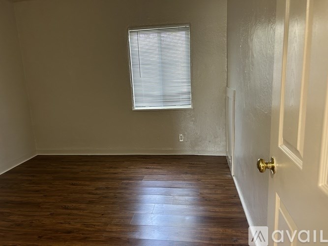 A room with a wooden floor and a white door.