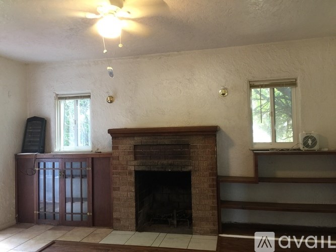 A room with a fireplace and a ceiling fan.