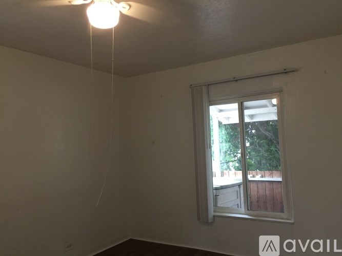 A room with a window and a ceiling fan.