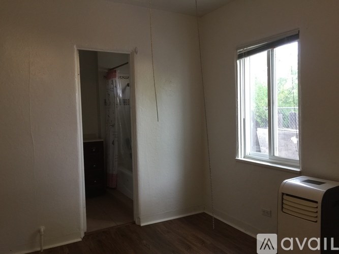A room with a window and a wall-mounted air conditioner unit.