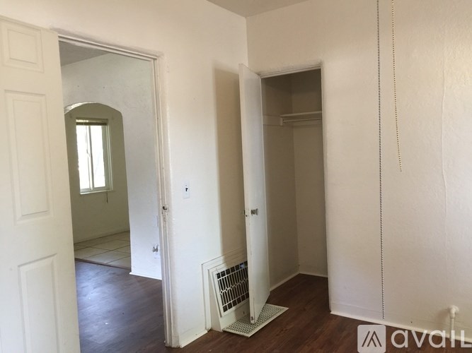 A room with a white door, a window, and a wall-mounted air conditioner unit.