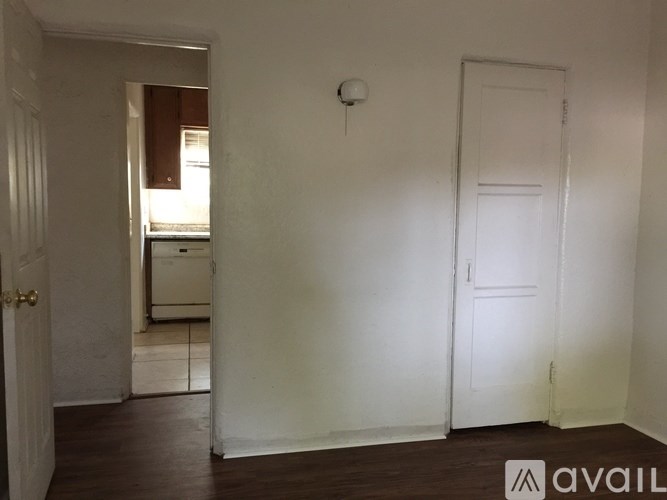 A room with a white door and a window with blinds.