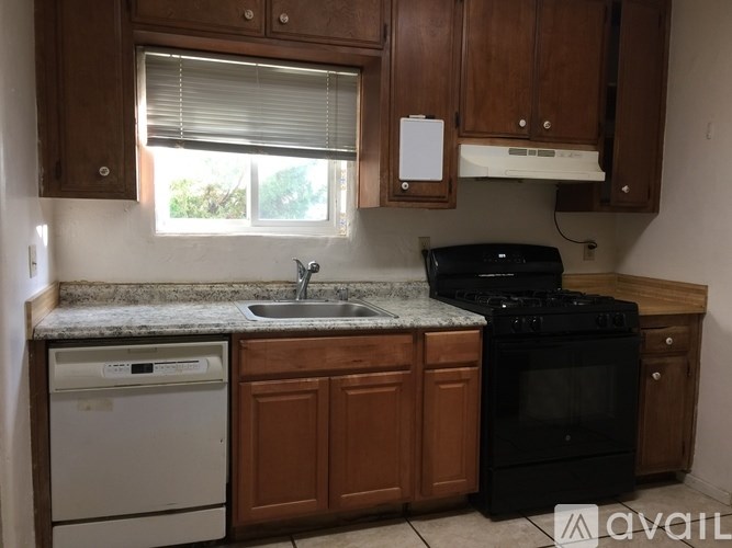 A kitchen with wooden cabinets and a black oven.