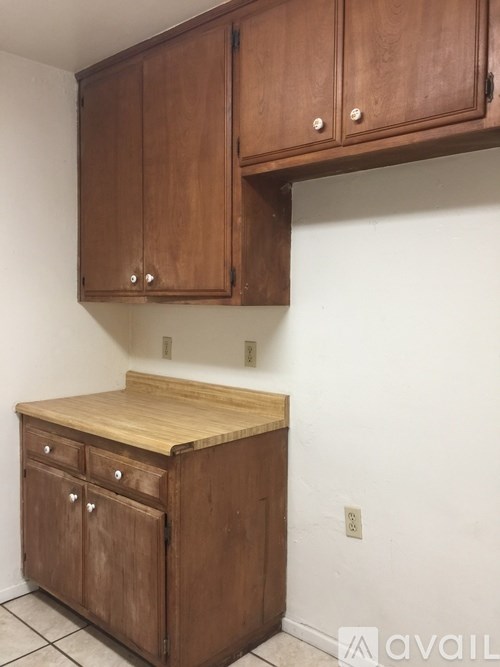 Brown wooden kitchen cabinets with a drawer and a countertop.