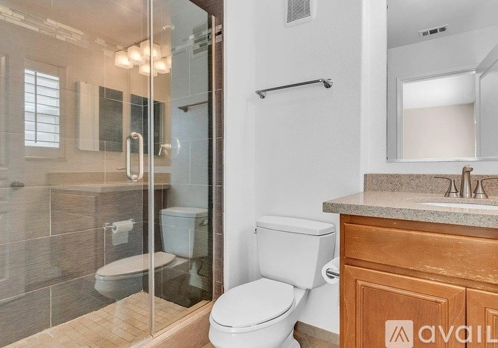 A bathroom with a toilet, a sink, and a walk-in shower.