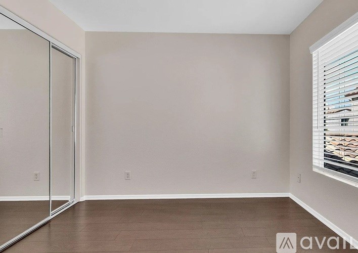 A room with a sliding glass door and a window with blinds.