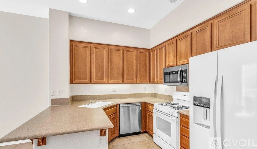 A kitchen with white appliances and wooden cabinets.