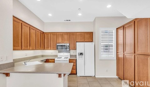 A kitchen with wooden cabinets and a white refrigerator.