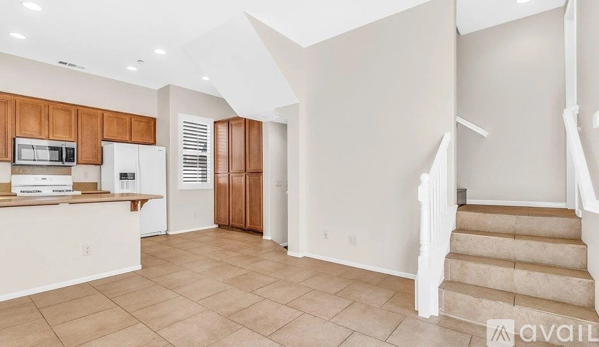 A kitchen with a refrigerator, microwave, and cabinets.