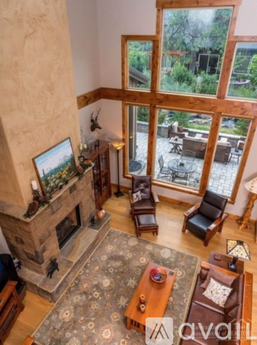 A living room with a fireplace and a view of the backyard.