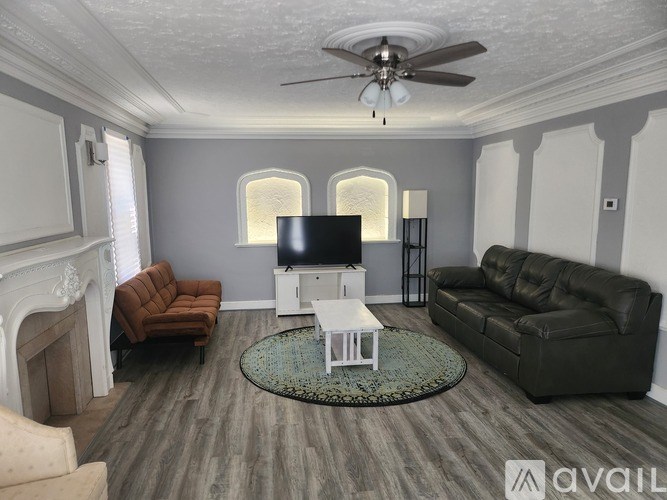 A living room with a fireplace, two couches, a coffee table, and a television.