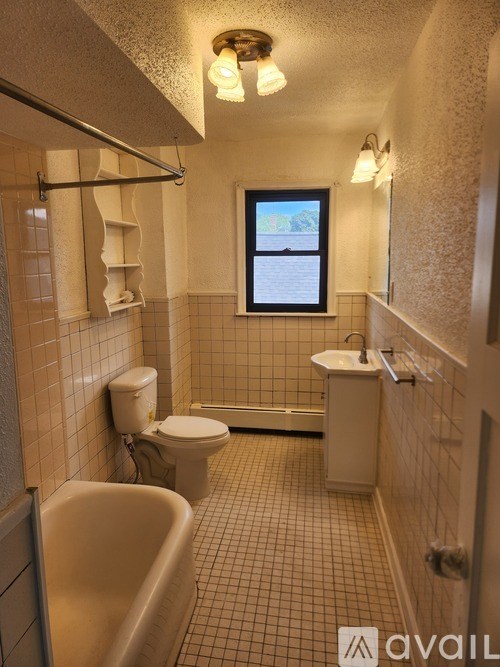 A bathroom with a tub, toilet and sink.