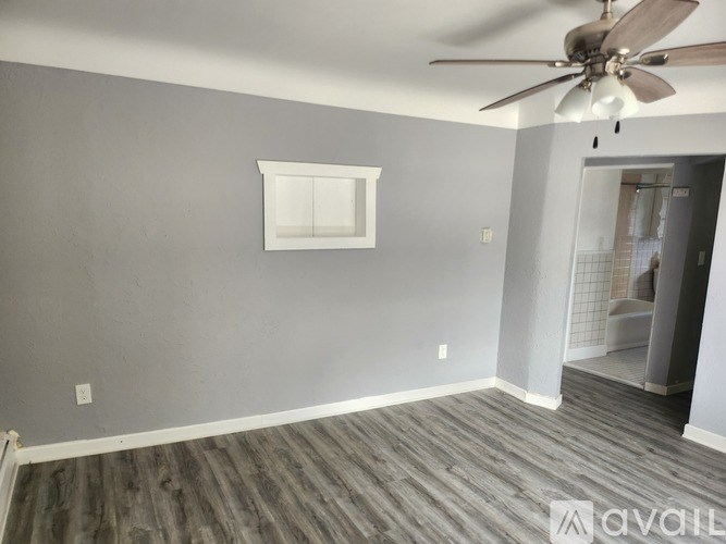 A room with a ceiling fan and a window.