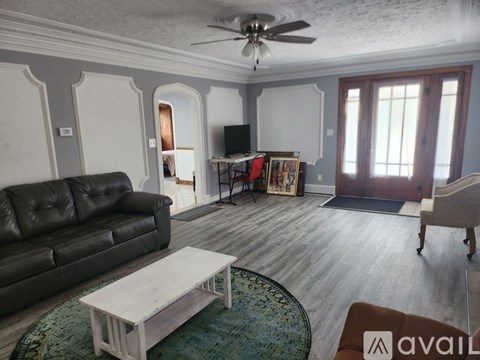 A living room with a black leather couch and a wooden coffee table.