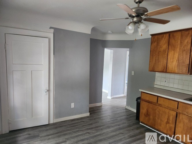 A kitchen with a fan and wooden cabinets.