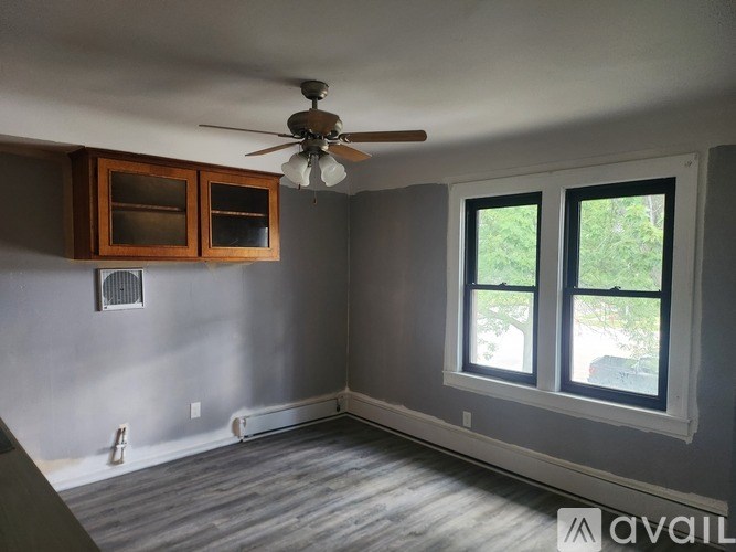 A room with a ceiling fan and a window.