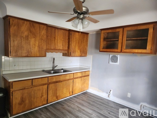 A kitchen with wooden cabinets and a ceiling fan.
