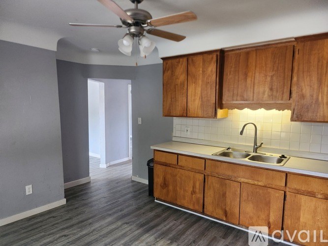 A kitchen with wooden cabinets and a fan.