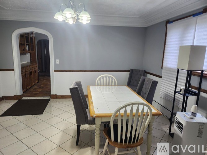 A dining room with a table and chairs.