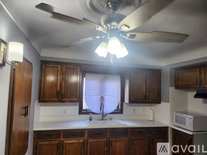 A kitchen with wooden cabinets and a white countertop.